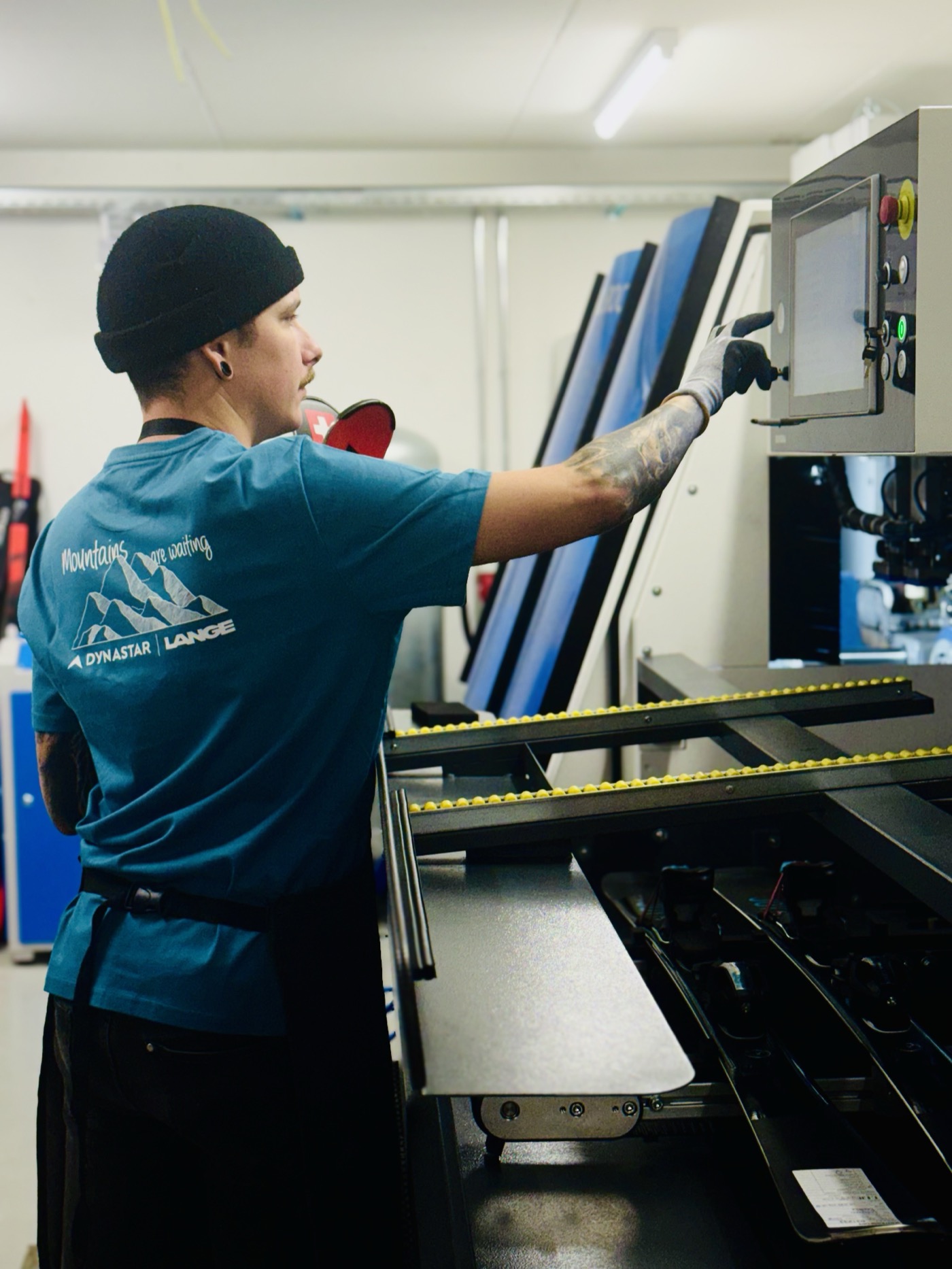 Technicien Intersport Dent-Blanche réglant la machine de service ski en atelier