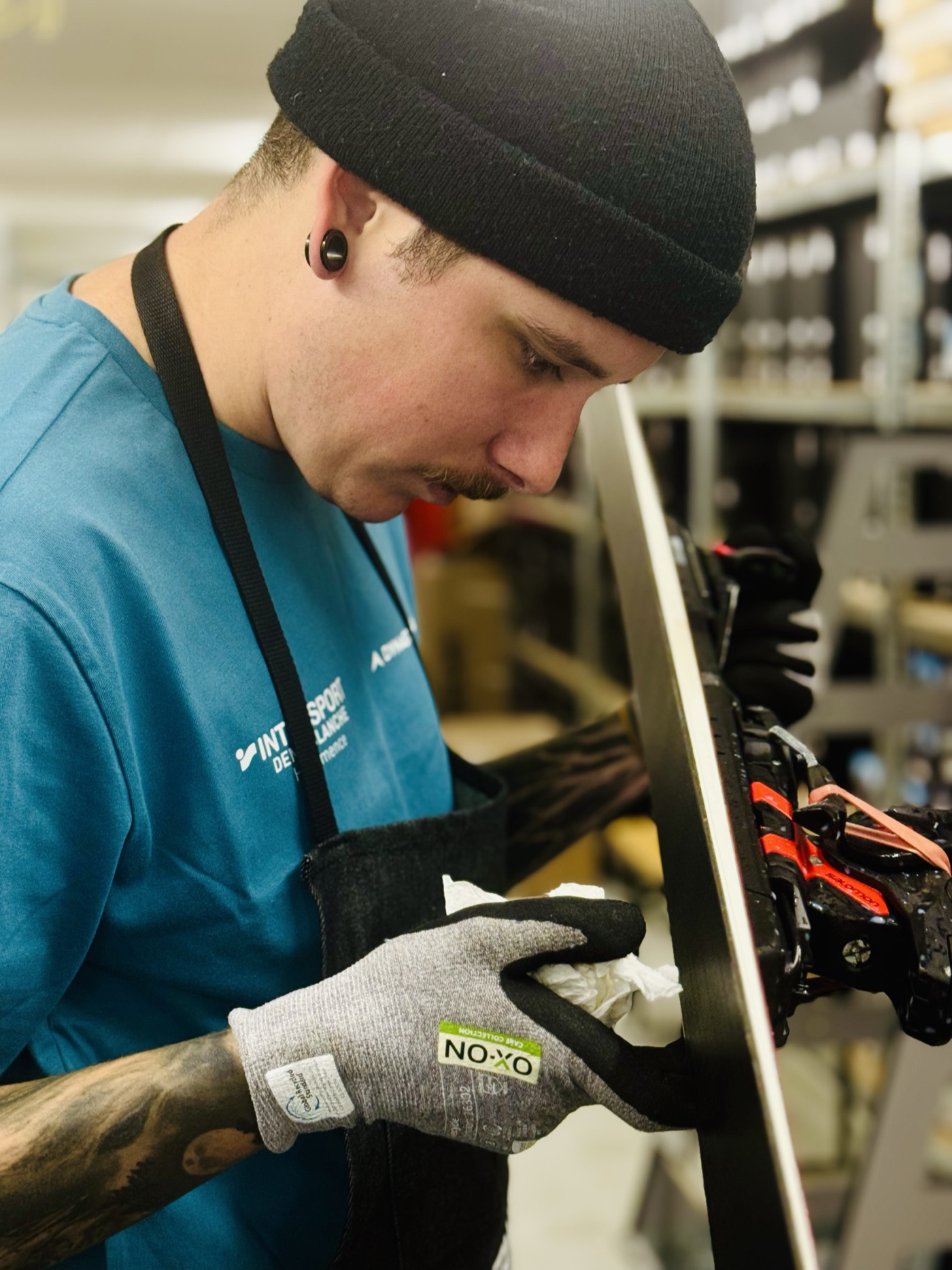 Technicien nettoyant la fixation d'un ski en atelier